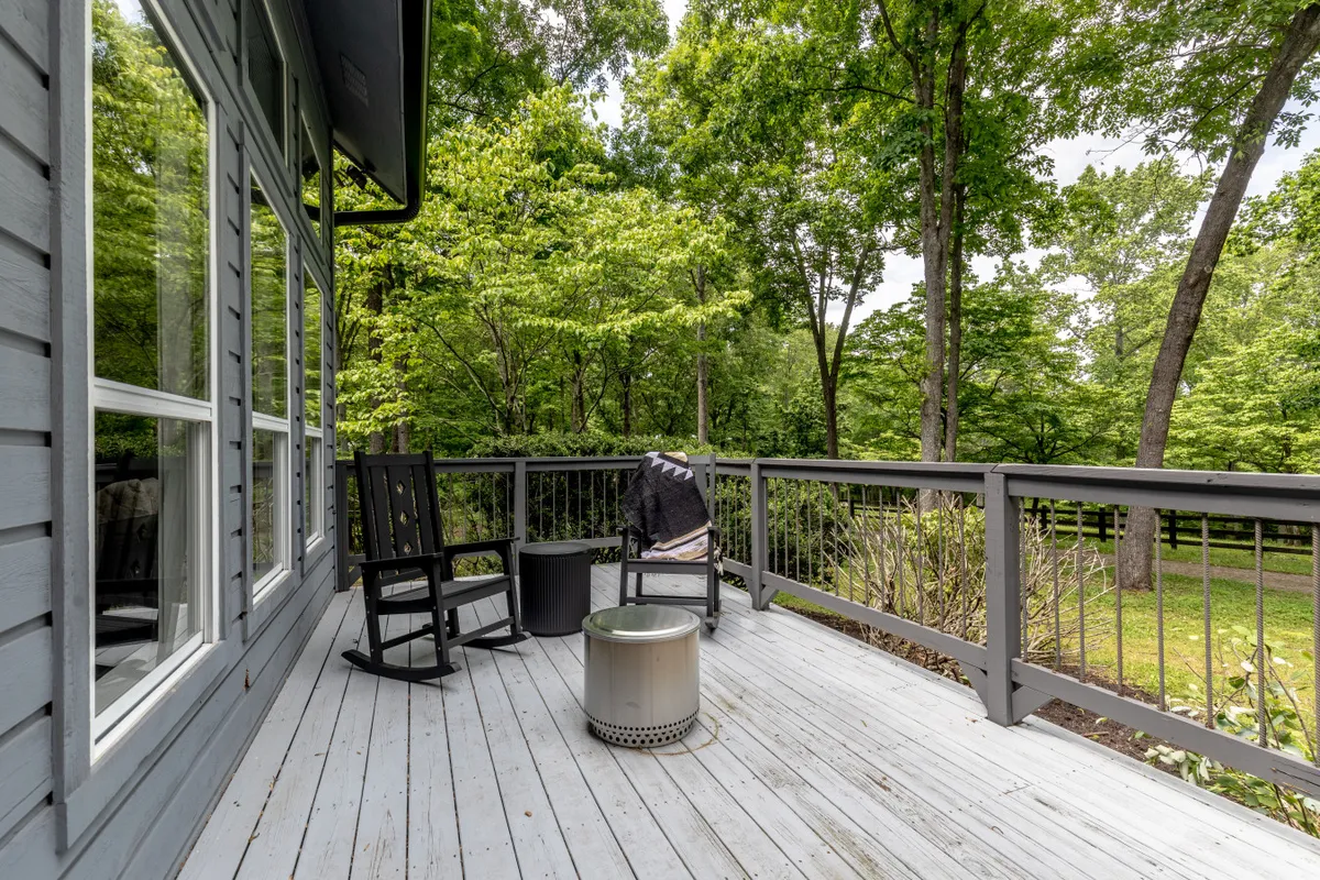 A tranquil seating area with deck chairs and a small table set amidst lush greenery, suggesting a comfortable spot to relax after a day of biking, hiking, or fishing.